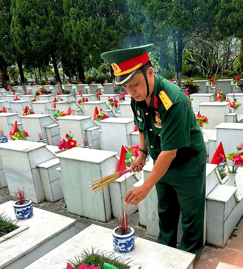 Ông Nguyễn Anh Tuấn thắp hương tại nghĩa trang.jpg